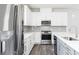Bright kitchen with stainless steel appliances, white cabinetry, grey backsplash, and island with sink at 2715 Stream Valley Lane Nw Nw Cir, Atlanta, GA 30318