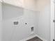 A bright laundry room with white walls, modern gray flooring, shelving, and hookups for a washer and dryer at 2715 Stream Valley Lane Nw Nw Cir, Atlanta, GA 30318