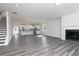 Open-concept living room with kitchen, fireplace, and staircase; gray wood flooring throughout at 2715 Stream Valley Lane Nw Nw Cir, Atlanta, GA 30318