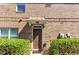 Welcoming front entrance features a brown door, brick facade, and manicured bushes at 805 Pleasant Hill Nw Rd # 343, Lilburn, GA 30047