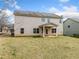 Rear of the home with a covered porch, showcasing siding, windows, and a spacious backyard with green grass at 9109 Alden Dr, Locust Grove, GA 30248