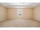 Spacious bedroom featuring neutral walls, carpet floors, and a large window with a ceiling fan at 9109 Alden Dr, Locust Grove, GA 30248