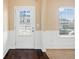 Entryway with white trim and panelling, a window, and a glass-paned front door at 9109 Alden Dr, Locust Grove, GA 30248