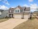 Beautiful two-story home with a brick and siding exterior, complemented by a two-car garage and a manicured lawn at 9109 Alden Dr, Locust Grove, GA 30248