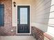 Close-up of the front door featuring a brick facade and classic black entry at 9109 Alden Dr, Locust Grove, GA 30248