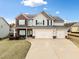 Charming two-story home with a brick and siding exterior, well-maintained lawn, and a three-car garage at 9109 Alden Dr, Locust Grove, GA 30248
