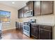 Kitchen with stainless steel appliances, tile backsplash, and dark wood cabinets at 9109 Alden Dr, Locust Grove, GA 30248