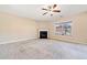 Open living room with a fireplace, plush carpeting, and large windows at 9109 Alden Dr, Locust Grove, GA 30248