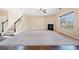 A large, open living room with a fireplace, plush carpeting, and large windows at 9109 Alden Dr, Locust Grove, GA 30248