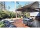 Beautiful wooden back deck with lounge chairs and dining table shaded by a large umbrella at 3504 Palace Ct, Tucker, GA 30084