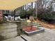 Multi-tiered backyard featuring a stone patio, garden beds, and mature trees at 3504 Palace Ct, Tucker, GA 30084