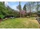 Beautifully landscaped backyard with lush green lawn, lounge chairs, privacy fence, and flowering trees at 3504 Palace Ct, Tucker, GA 30084