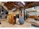 Unfinished basement with exposed ductwork and cinderblock walls opens to a workshop area with wood flooring at 3504 Palace Ct, Tucker, GA 30084