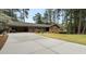 Long concrete driveway leads to brick home with covered carport and manicured lawn at 3504 Palace Ct, Tucker, GA 30084