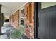 Covered porch with slate tile, brick wall, modern house numbers, and matte black door at 3504 Palace Ct, Tucker, GA 30084