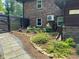 Landscaped walkway with river rock, plants, and black painted fence along exterior of home at 3504 Palace Ct, Tucker, GA 30084