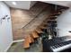 Modern stairway with wooden steps, black metal railing, and musical instruments at 3504 Palace Ct, Tucker, GA 30084