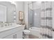 Well-lit bathroom with a shower-tub combination, gray tiling, and modern fixtures at 3547 Cedarvale Ct, Powder Springs, GA 30127