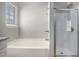Bathroom featuring a soaking tub with a shower and a glass shower door at 441 Concord Cir, Mcdonough, GA 30253