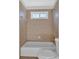 Shower with tile surround, toilet, and window providing natural light at 511 Millwood Ct, Canton, GA 30114