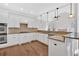 Open kitchen with white cabinets, granite countertops, hardwood floors and stainless appliances at 511 Millwood Ct, Canton, GA 30114