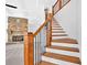 Beautiful staircase with wooden steps, black metal railing, and a stone fireplace in the background at 511 Millwood Ct, Canton, GA 30114