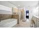 Bathroom features a glass-enclosed shower, tub, and window, with tiled accents at 555 Birkdale Dr, Fairburn, GA 30213