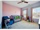 This bedroom includes pink walls, a blue chair, and a blue crib at 555 Birkdale Dr, Fairburn, GA 30213