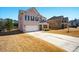 Two-story home featuring brick, stone accents, two-car garage, and long driveway nestled in a suburban community at 555 Birkdale Dr, Fairburn, GA 30213