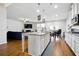 Open-concept kitchen with granite island, modern appliances, white cabinets, and breakfast area overlooking the Gathering room at 555 Birkdale Dr, Fairburn, GA 30213