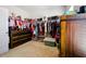 Walk-in closet with custom wood cabinets and ample clothing storage racks at 555 Birkdale Dr, Fairburn, GA 30213