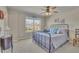 Bedroom boasts soft carpet, a ceiling fan, a large window providing natural light, and a comfortable iron bed frame at 194 Lakestone Parkway, Woodstock, GA 30188