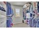Walk-in closet featuring custom shelving and racks, lots of room for storage, and a window providing natural light at 194 Lakestone Parkway, Woodstock, GA 30188
