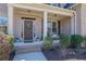 Inviting covered front porch with brick accents and a charming seating area at 194 Lakestone Parkway, Woodstock, GA 30188