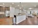 Open-concept kitchen features an island with granite countertops, stainless steel appliances, and hardwood floors at 194 Lakestone Parkway, Woodstock, GA 30188