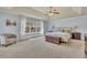 Spacious main bedroom with a ceiling fan, a chest, soft carpet, and lots of natural light through the big window at 194 Lakestone Parkway, Woodstock, GA 30188