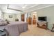 Bedroom featuring neutral walls, carpeting, television, and adjoining bathroom access at 441 Highlands Loop, Woodstock, GA 30188