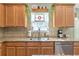 Well-maintained kitchen with a stainless steel sink and appliances, granite countertops, and wood cabinets at 441 Highlands Loop, Woodstock, GA 30188