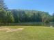 Scenic lake view surrounded by lush green grass and mature trees at 441 Highlands Loop, Woodstock, GA 30188