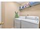 Functional laundry room with white washer and dryer and storage shelves at 441 Highlands Loop, Woodstock, GA 30188