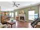 Living room with hardwood floors and fireplace open to kitchen and breakfast nook at 441 Highlands Loop, Woodstock, GA 30188
