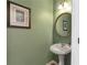 Cozy powder room featuring a pedestal sink, decorative mirror, and soft green walls at 441 Highlands Loop, Woodstock, GA 30188