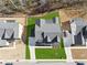 Overhead shot of a house featuring a manicured lawn, long driveway, and dark-gray roof in a new community at 7560 Wild Violet Dr, Cumming, GA 30040
