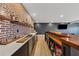 Charming bar with brick wall backdrop, floating shelves, ample storage, quartz countertop, and designer sink at 7560 Wild Violet Dr, Cumming, GA 30040