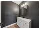 Modern powder room with white vanity, ample storage, and stylish dark gray walls at 7560 Wild Violet Dr, Cumming, GA 30040