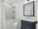 Clean bathroom with a vanity, toilet, and shower-tub with herringbone tiling at 7560 Wild Violet Dr, Cumming, GA 30040