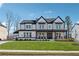 Charming two-story home with a manicured lawn and inviting, covered front porch at 7560 Wild Violet Dr, Cumming, GA 30040