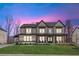 Elegant two-story modern farmhouse with a manicured lawn, covered porch, and a double-door entryway at 7560 Wild Violet Dr, Cumming, GA 30040