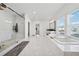 Spacious main bathroom with soaking tub, walk-in shower, and marble floors at 7560 Wild Violet Dr, Cumming, GA 30040