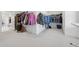 Large walk-in closet featuring full-length shelving, carpet, and a dressing area at 7560 Wild Violet Dr, Cumming, GA 30040